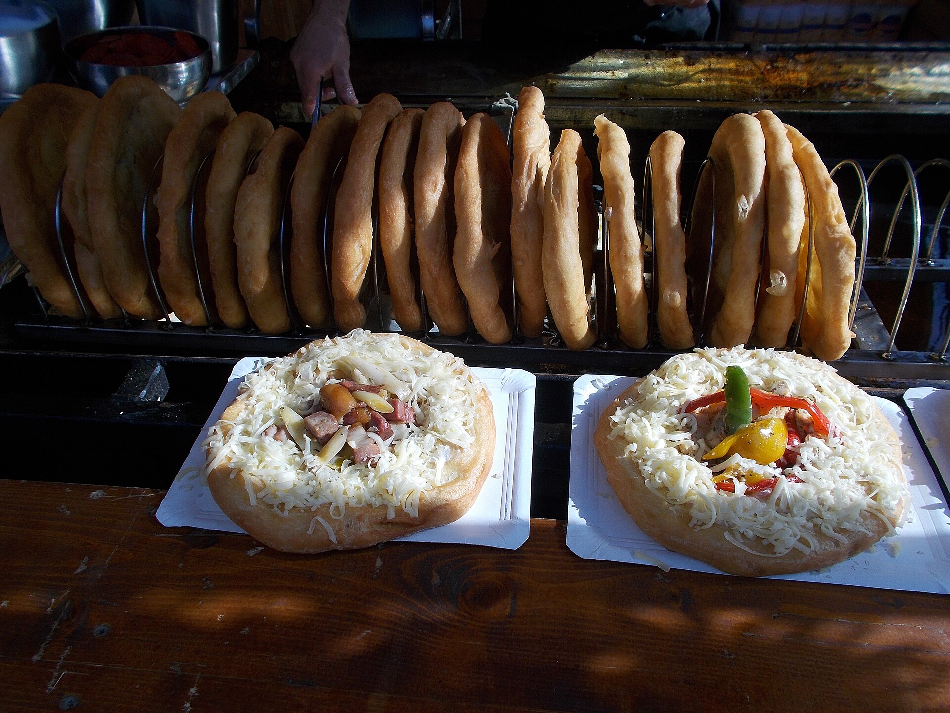 Fried lángos topped with cheese at a street food stall on Szabadság tér, Budapest